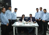 Zayca team gathered around guests at a table